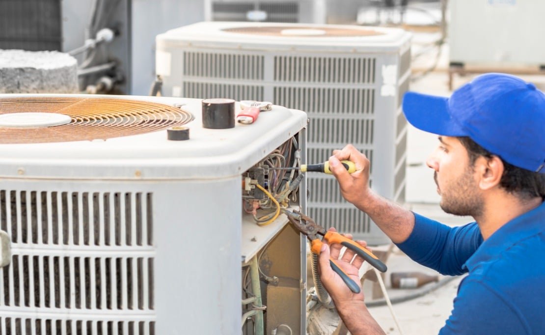 Technician repairing a residential air conditioning system